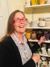 Mrs. Reese rearranging dishes in the ceramics room