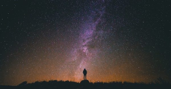 Person gazing up at the night sky; Photo by Greg Rakozy on Unsplash